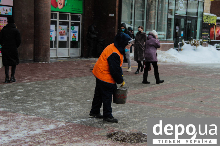 Жінка розсипає сіль перед виходом з метро Хрещатик
