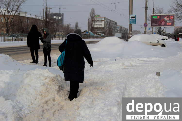 Люди пробираються через сніг в Києві